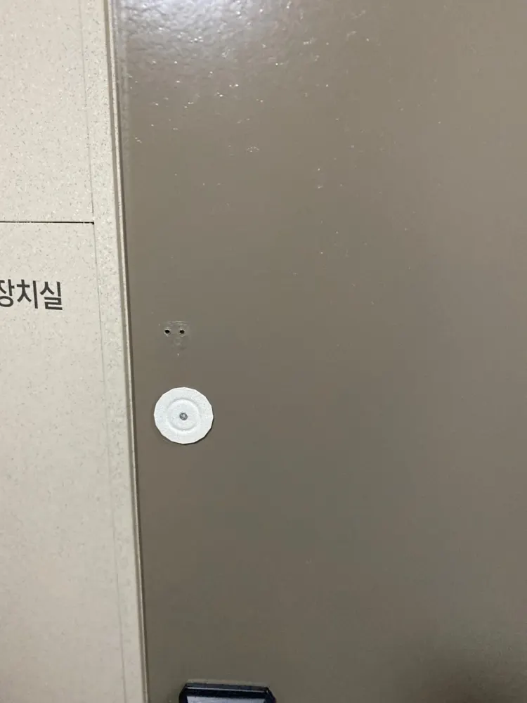 교체된 잠금장치 주변에 구멍과 얼룩이 남은 현관문 표면