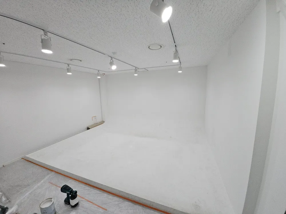 보양재와 도장 도구가 놓인, 도장이 진행 중인 넓은 벽면과 바닥